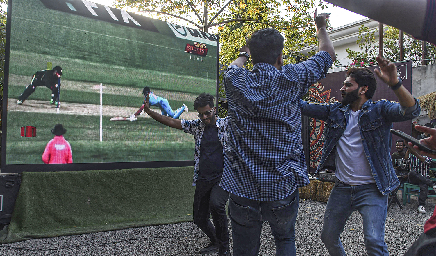 Pakistani cricket fans react while watching the ICC men's Twenty20 World Cup 2022 cricket match between India and Pakistan, on a screen in Lahore on October 23, 2022. (AFP/File)