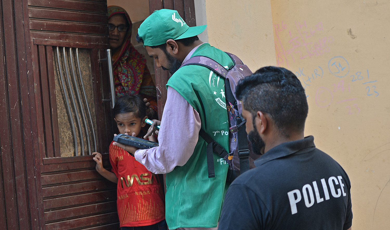 An official, center, from the Pakistan Bureau of Statistics uses a digital device to collect information from a resident during door-to-door the first ever digital national census in Karachi on March 1, 2023. (AFP/File)