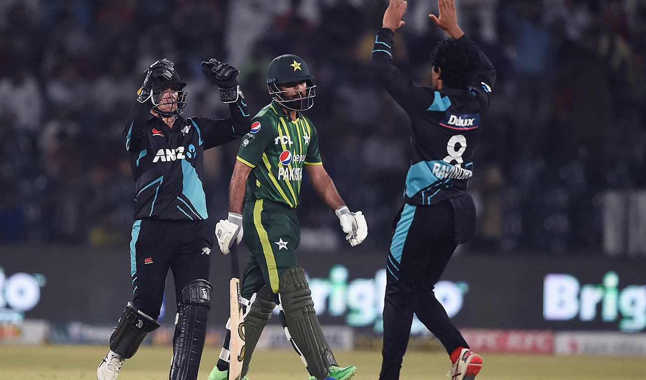 New Zealand's wicketkeeper captain Tom Latham (L) celebrates with teammate Rachin Ravindra (R) after the dismissal of Pakistan's Fakhar Zaman (C) during the third Twenty20 international cricket match between Pakistan and New Zealand at the Gaddafi Cricket Stadium in Lahore on April 17, 2023.(AFP/File)