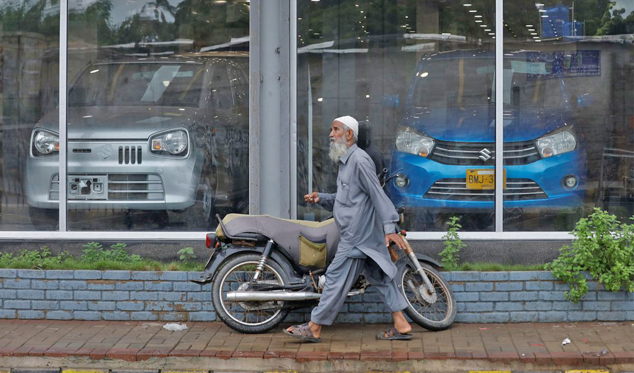 A man walks past a Suzuki outlet, displaying cars in Karachi, Pakistan, on July 27, 2022. (REUTERS/File)