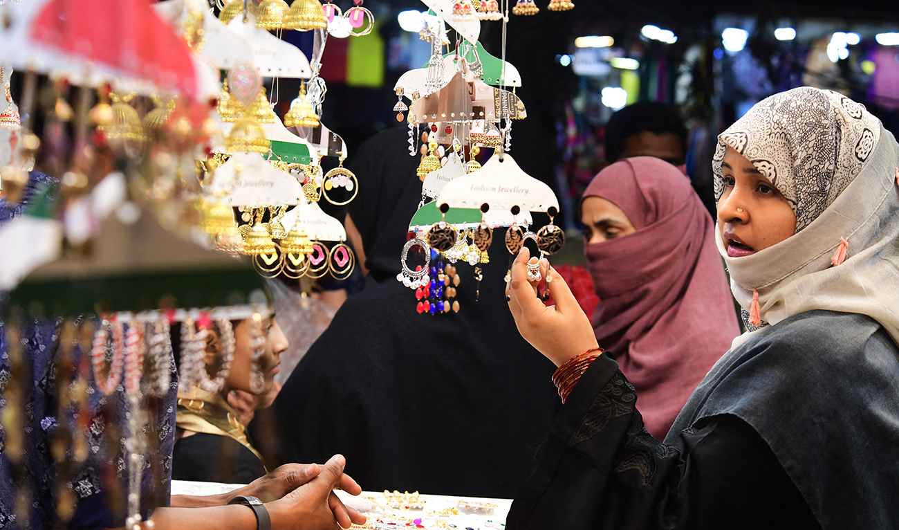 A woman looks at jewelry at market during shopping ahead of the upcoming festival of Eid al-Fitr in Karachi on April 19, 2023. (AFP)