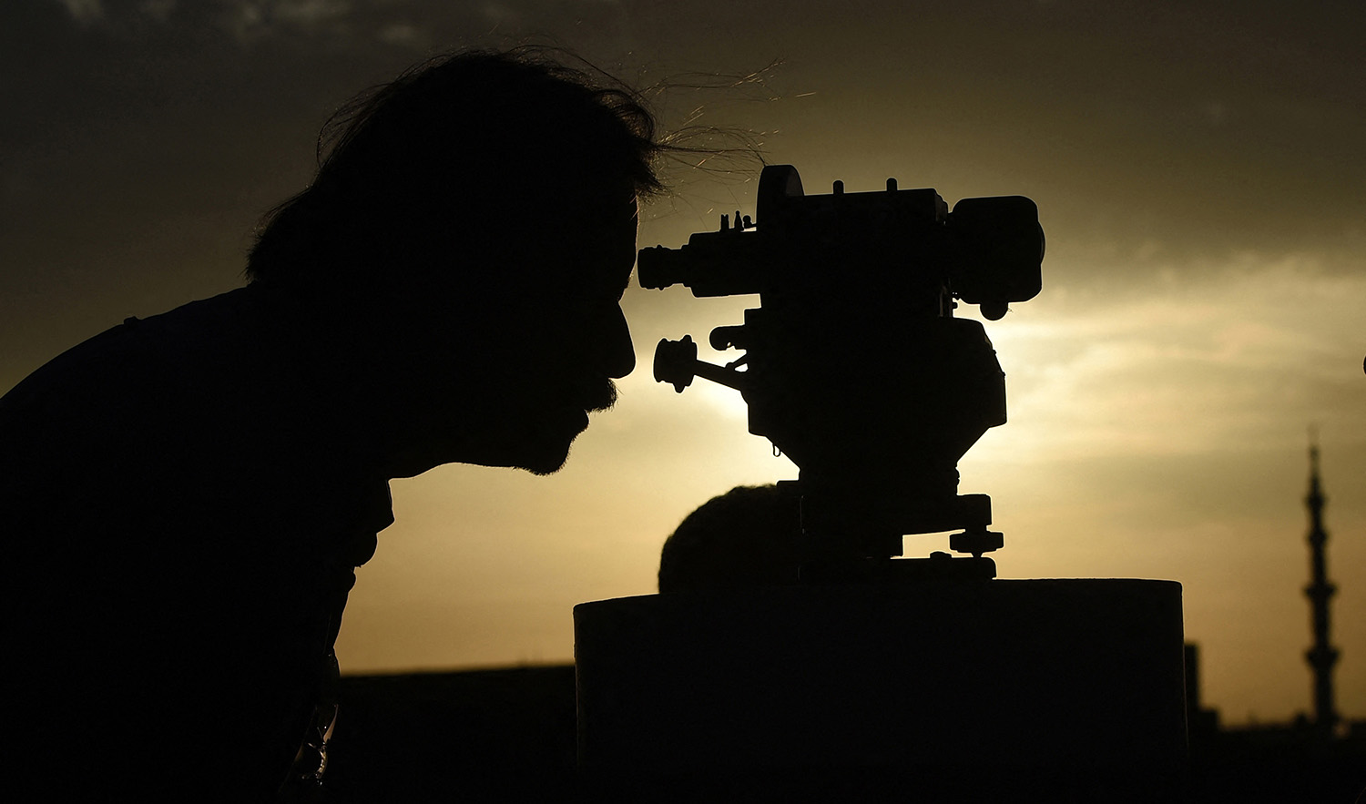 A member of Pakistan's moon-sighting committee uses a telescope to observe the appearance of the Ramadan Moon in Karachi on March 22, 2023. (AFP/File)