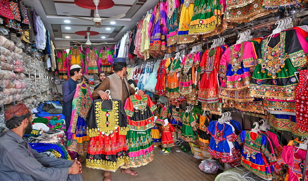 Shopkeepers display clothes at a market ahead of the Eid al-Fitr festival to mark the end of the holy fasting month of Ramadan in Rawalpindi, Pakistan, on April 20, 2023. (AFP/File)