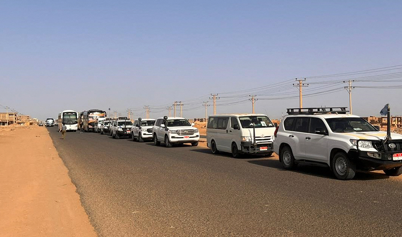 A convoy leaving Khartoum advances on a road towards Port Sudan, on April 23, 2023, as people flee the battle-torn Sudanese capital. (Photo courtesy: AFP)