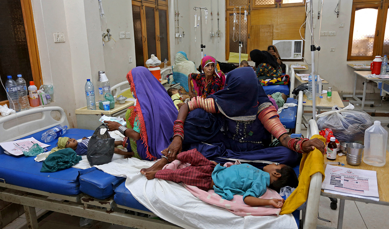 Internally displaced people take care of their children under treatment for malaria and gastro in the flood-hit Hyderabad city of Sindh province on September 11, 2022. (AFP/FILE)