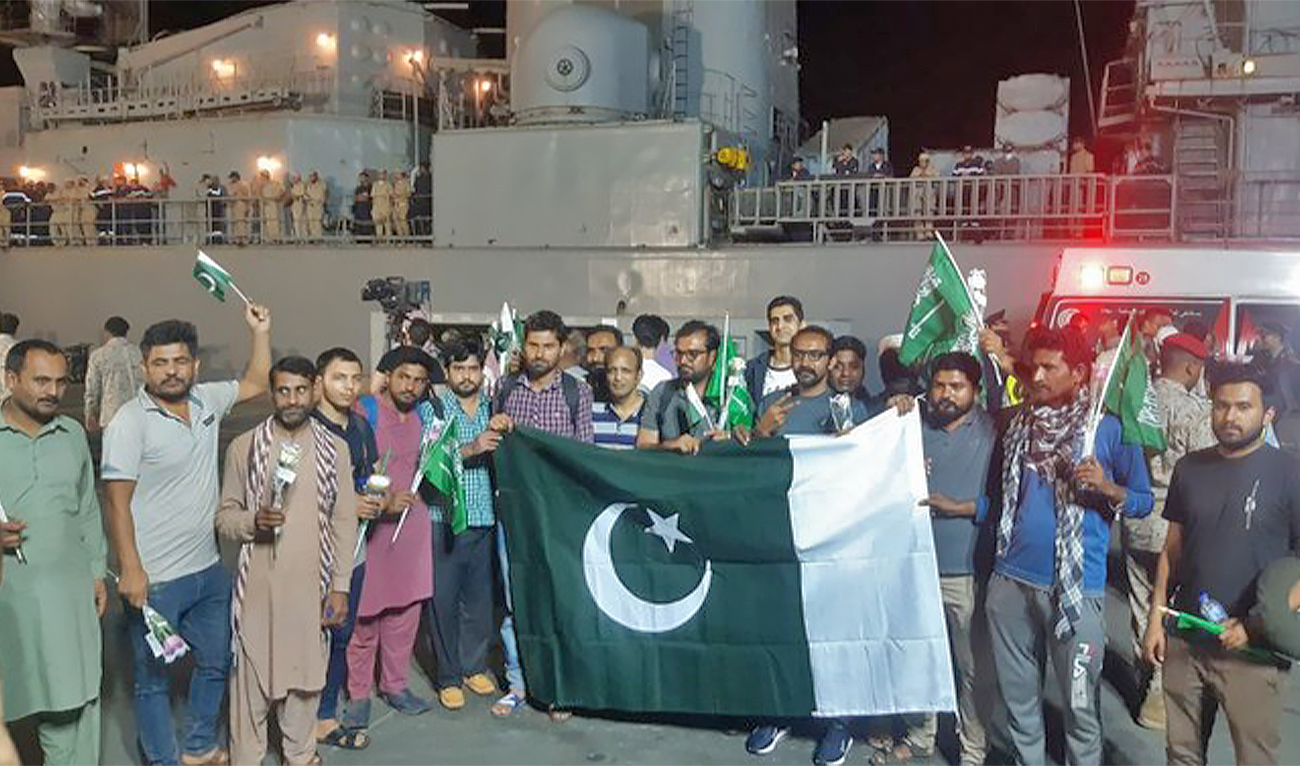 Pakistani nationals evacuated from Sudan pose for a picture with the national flag upon their arrival at King Faisal Navy base in Jeddah, Saudi Arabia, on April 26, 2023. (AN photo by Mohammed Alkinani)