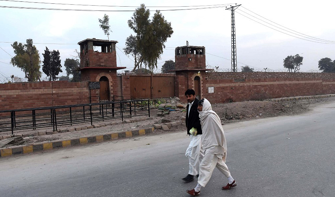 In this file photo, taken on December 31, 2014, Pakistani pedestrians walk past the central jail in Peshawar. (Photo courtesy: AFP/File)