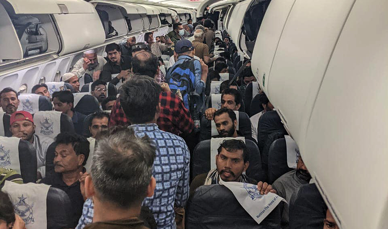 This handout picture taken and released by Pakistan Air Force (PAF) shows a group of Pakistani nationals evacuated from strife-torn Sudan aboard a PAF aircraft in Karachi on April 30, 2023. (Photo courtesy: PAF)