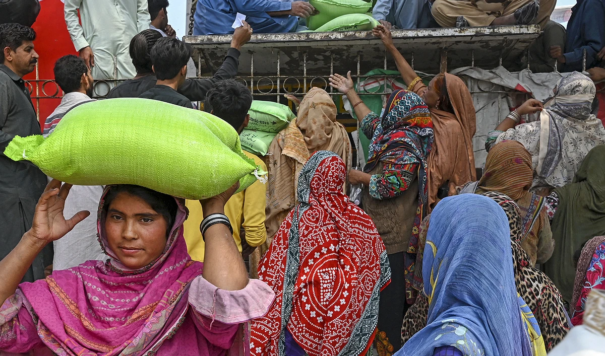 Women collect free bags of flour from a government distribution point in Lahore on April 2, 2023. (Photo courtesy: AFP)