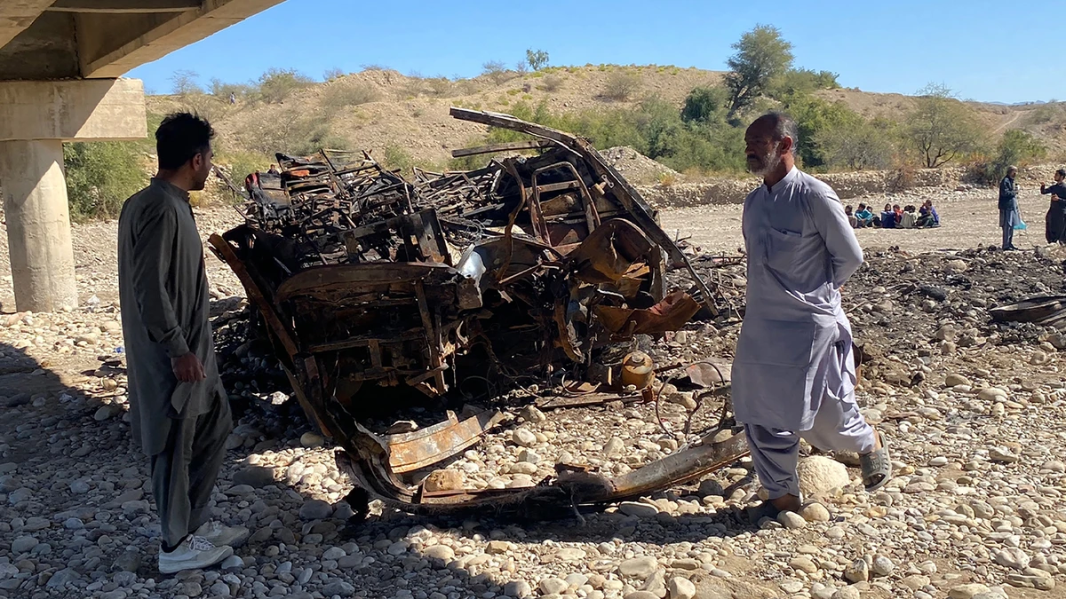 Residents look at the wreckage of a passenger bus in Lasbela district of Pakistan's Balochistan province on January 29, 2023. (AFP/File)