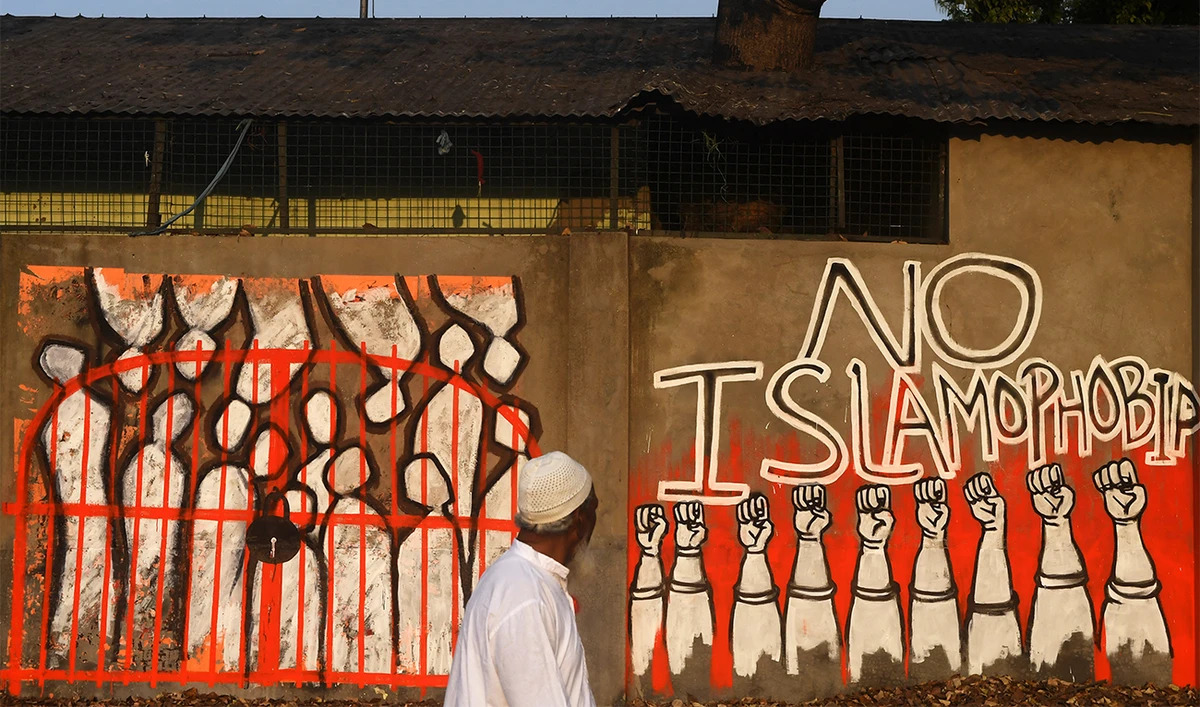 A man walks past a wall reading 'No Islamophobia' in Kolkata, India, on February 14, 2020. (AFP/File)