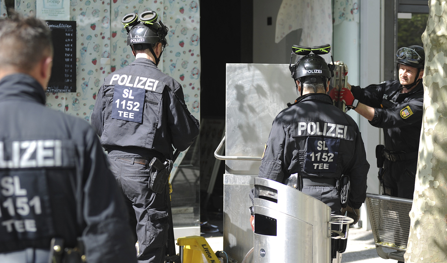 Police officers secure evidence during a raid in Saarlouis, Germany, on May 3, 2023. (DPA via AP)