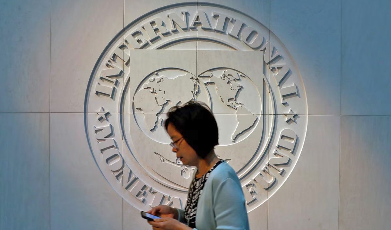 A woman walks past the International Monetary Fund (IMF) logo at its headquarters in Washington, US, on May 10, 2018. (REUTERS/File)