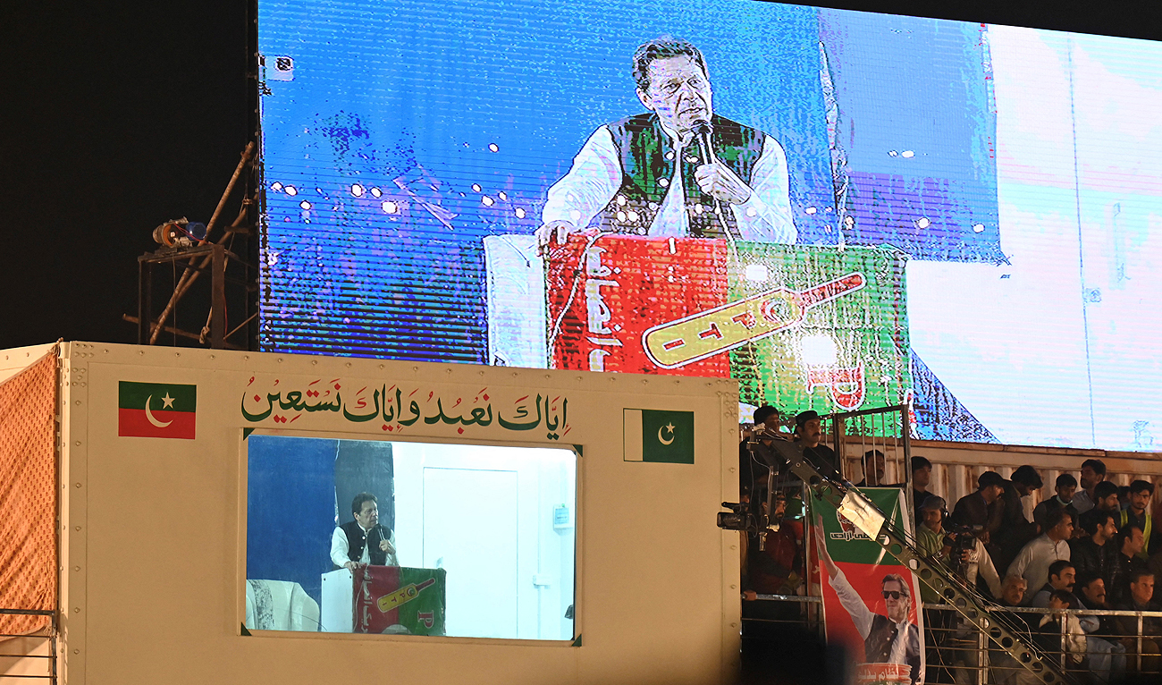 In this file picture, taken on March 26, 2023, Pakistan's former prime minister Imran Khan (bottom L) speaks to his supporters from behind a bulletproof shield at a rally in Lahore. (Photo courtesy: AFP/File)