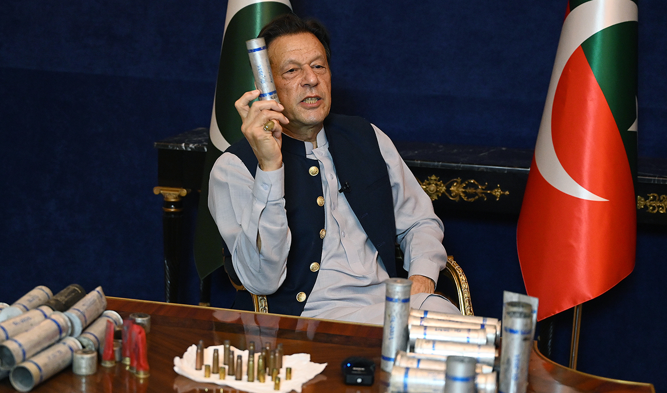 Former Pakistan's prime minister Imran Khan speaks during an interview with AFP at his residence in Lahore on March 15, 2023, while displaying teargas shells fired by riot police during clashes with hundreds of his supporters gathered at his residence to prevent his arrest. (AFP/File)