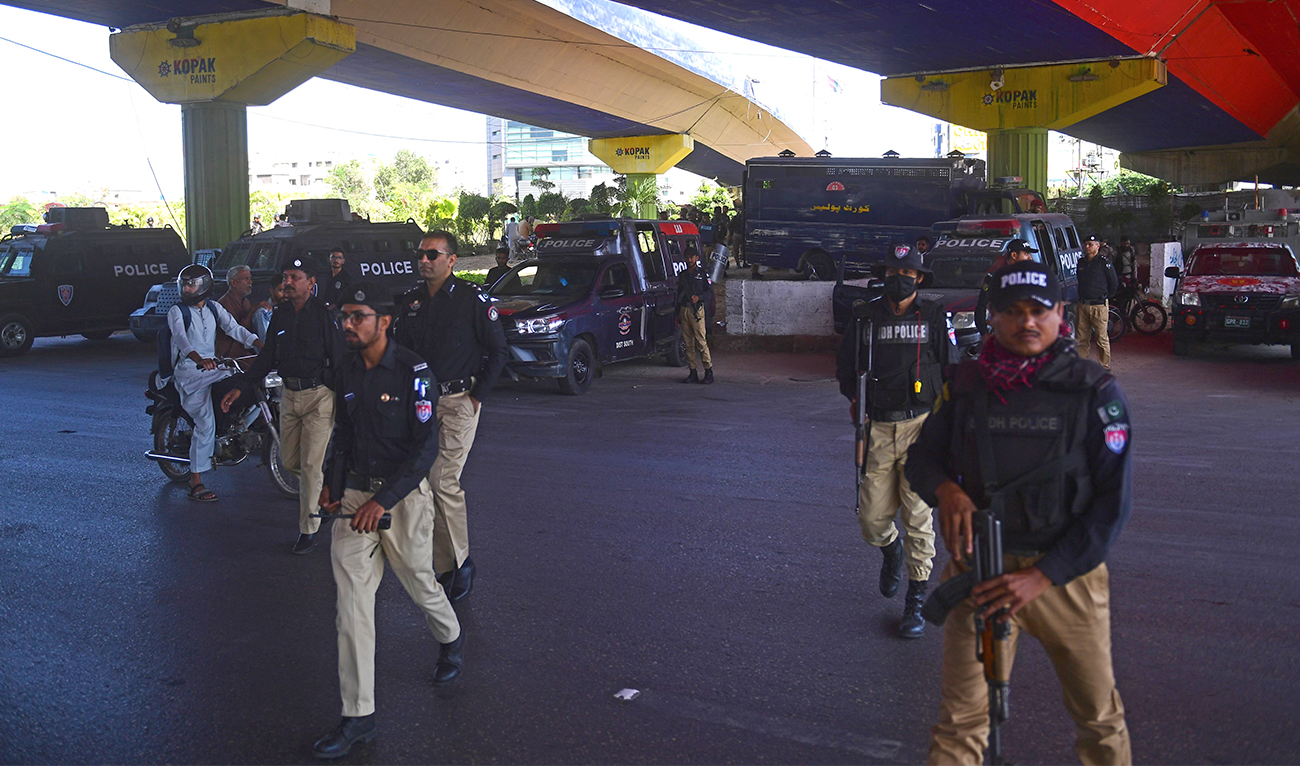 Policemen stand guard along a roadside in Karachi on May 10, 2023. (AFP)