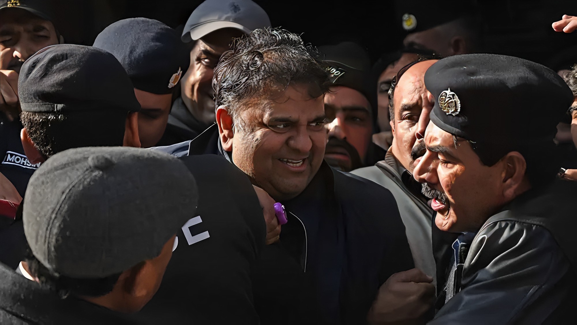 Police officials escort Pakistan's former information minister Fawad Chaudhry (C) as they leave the court after a hearing in Islamabad on January 27, 2023. (AFP/File)