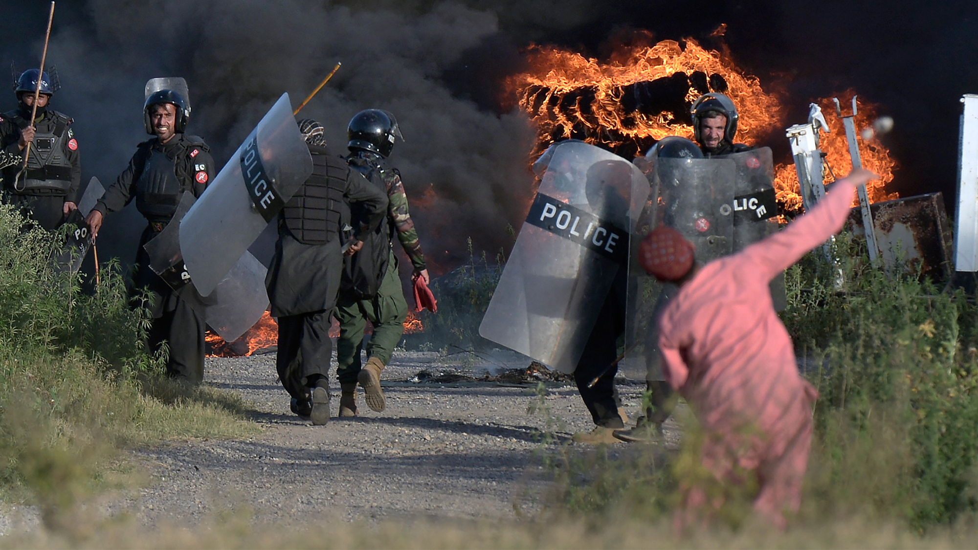 Police officers throw stones towards supporters of Pakistan's former Prime Minister Imran Khan during clashes, in Islamabad, Pakistan, on May 10, 2023. (AP)