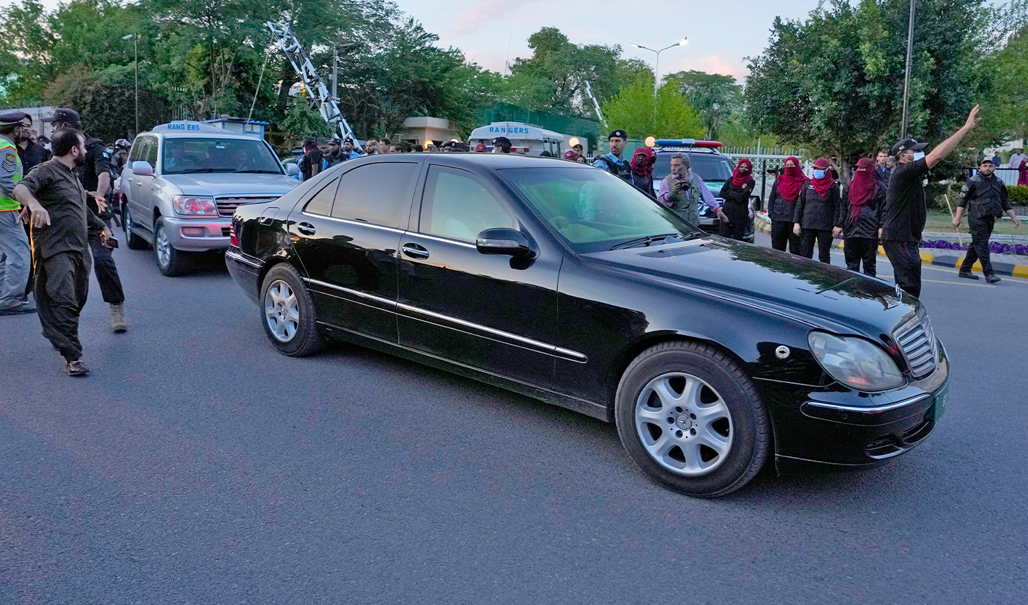 Police officers clear the way for the car carrying Pakistan's former Prime Minister Imran Khan after he appeared at the Supreme Court, in Islamabad, Pakistan, on May 11, 2023. (AP)