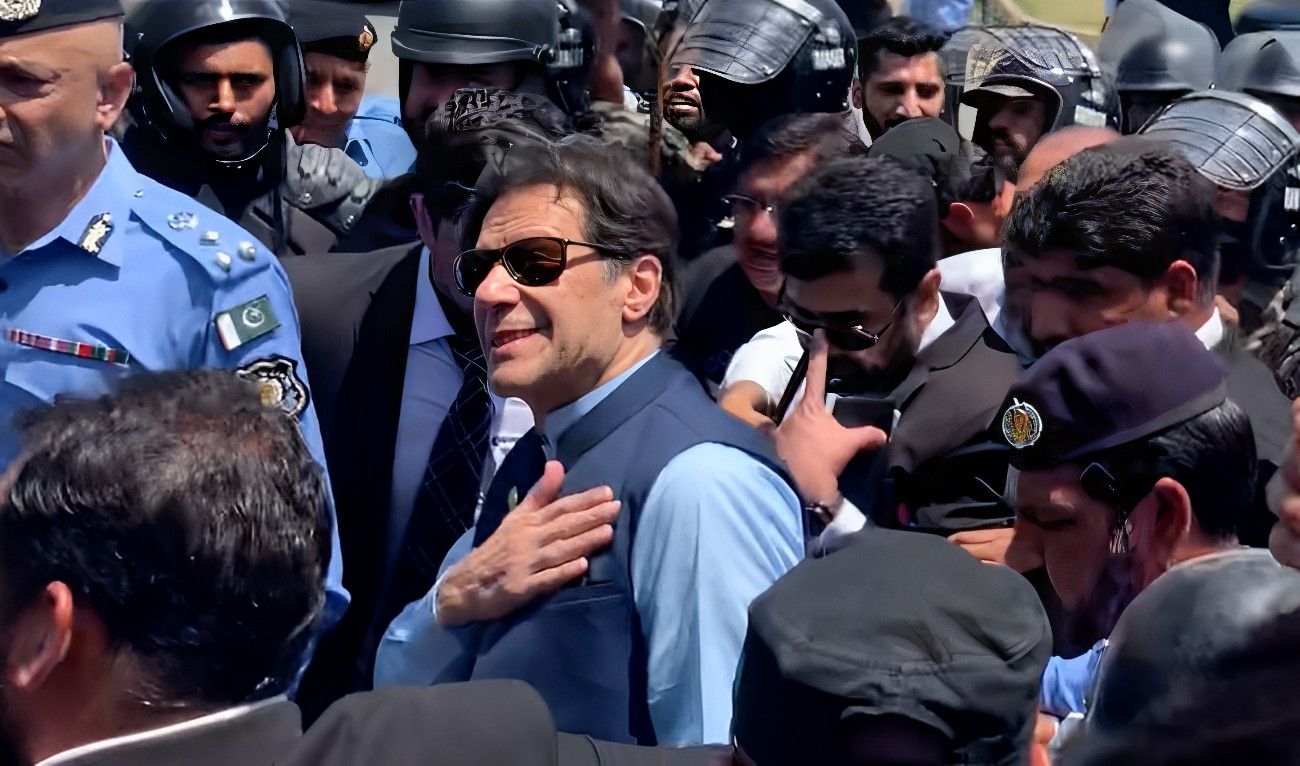 Policemen escort Pakistan's former Prime Minister Imran Khan (C) as he arrives at the high court in Islamabad on May 12, 2023. (AN photo by Baker Atyani)