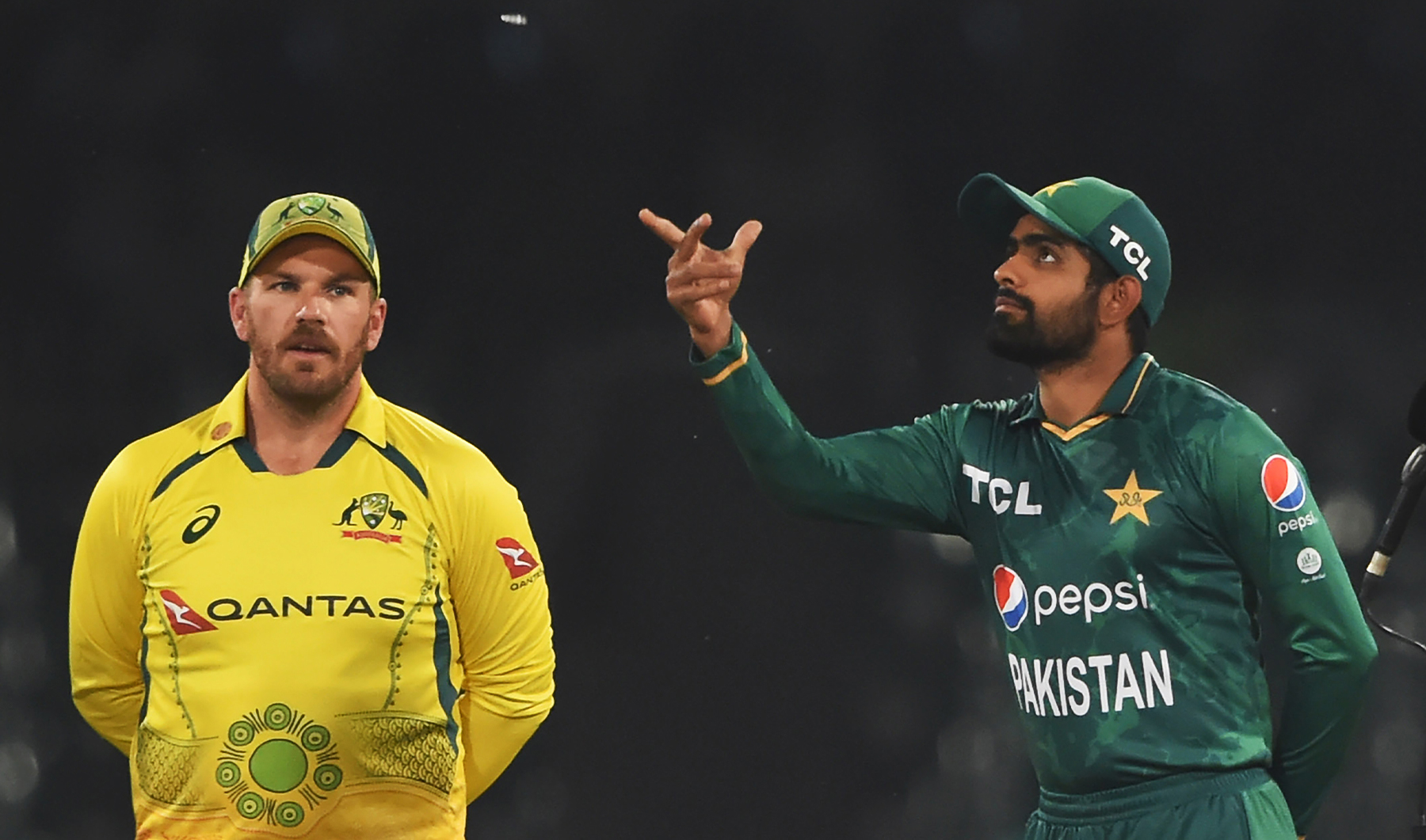 Pakistan's captain Babar Azam (R) tosses the coin as his Australian counterpart Aaron Finch watches before the start of the Twenty20 international cricket match between Pakistan and Australia at the Gaddafi Cricket Stadium in Lahore on April 5, 2022. (AFP/File)