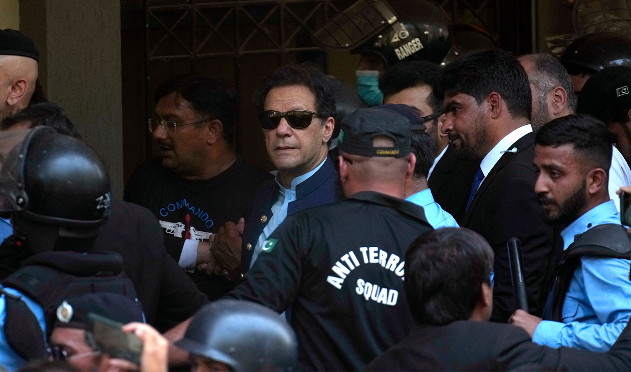 Pakistan's former Prime Minister Imran Khan, center, is escorted by security officials as he arrive to appear in a court, in Islamabad, Pakistan, on May 12, 2023. (AP/File)