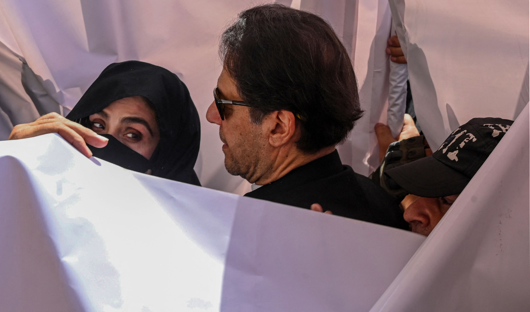 Former Pakistan prime minister Imran Khan (C) with his wife Bushra Bibi (L) arrive to appear at a high court in Lahore on May 15, 2023. (AFP)