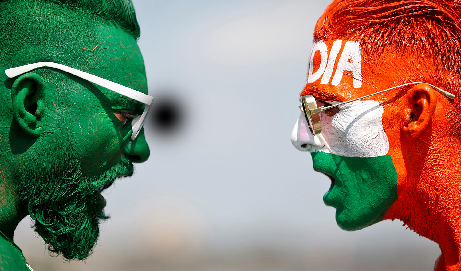 Cricket fans, with their faces painted in the Indian and Pakistani national flag colors, pose for a picture ahead of the first match between India and Pakistan in Twenty20 World Cup super 12 stage in Dubai, in Ahmedabad, India, on October 23, 2021. (REUTERS/File)