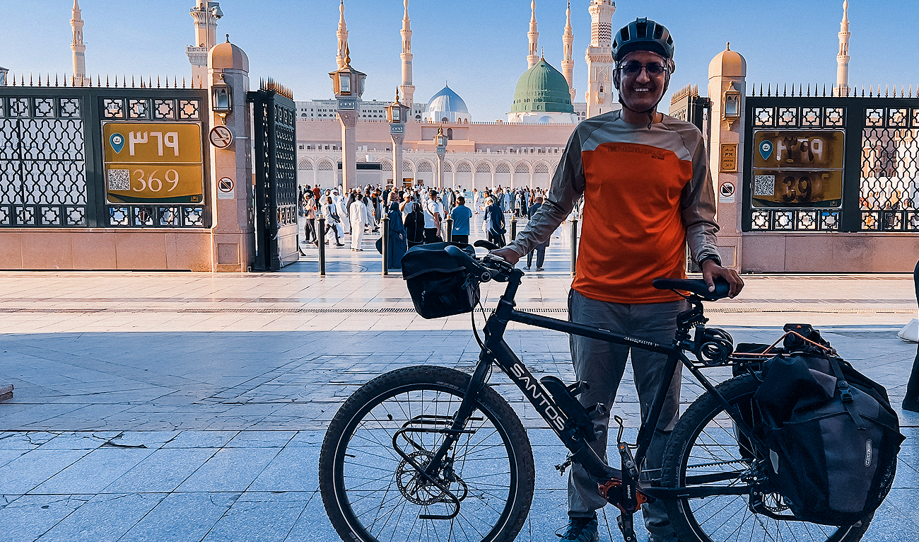 Kamran Ali, a Pakistani adventurer who travels on his bicycle, poses for a picture in front of Al-Masjid an-Nabawi in Madinah, Saudi Arabia on April 13, 2023. (Photo courtesy: Kamran Ali)