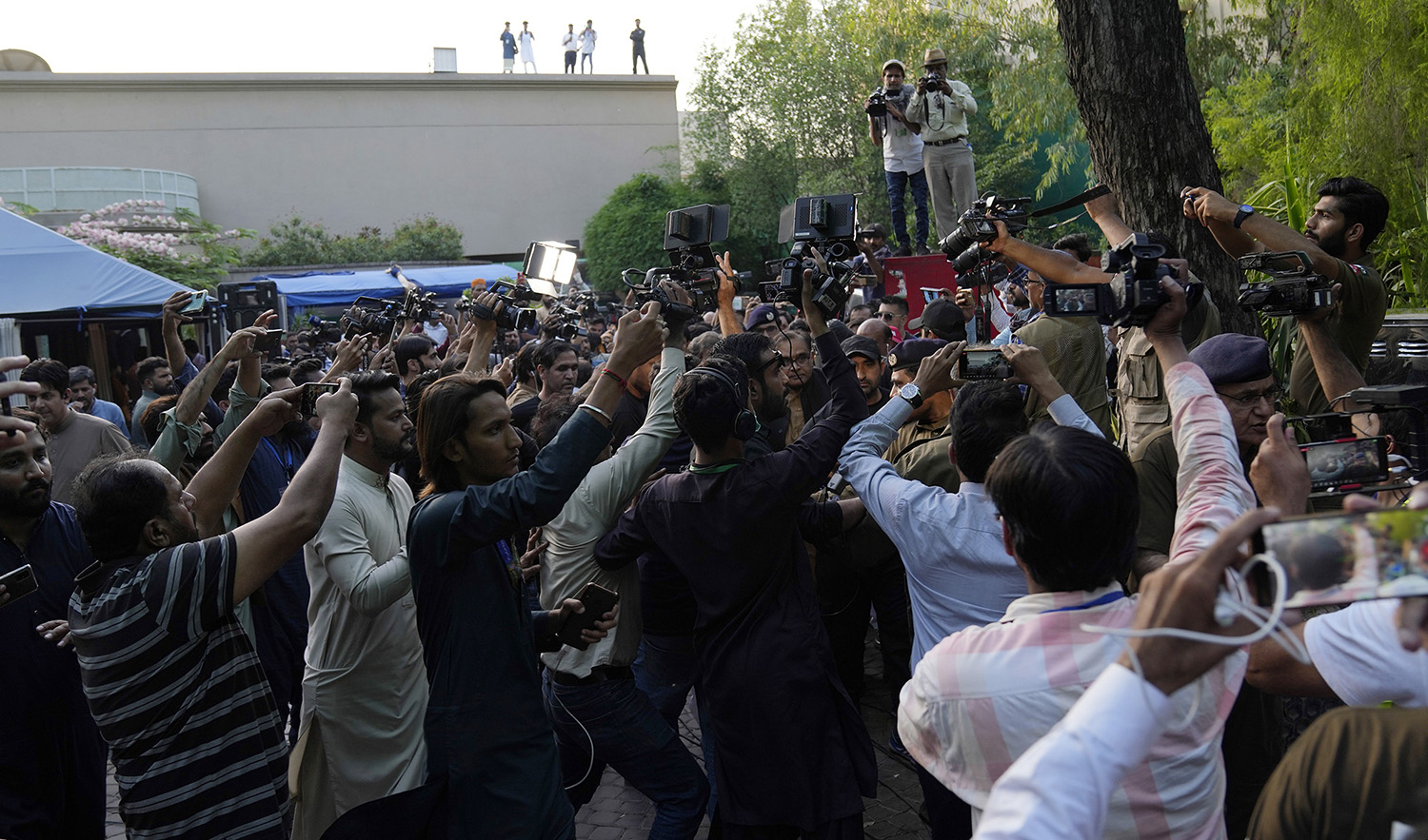 Members of the media conduct their television report in Imran Khan's house in Lahore, Pakistan, on May 19, 2023. (AP)