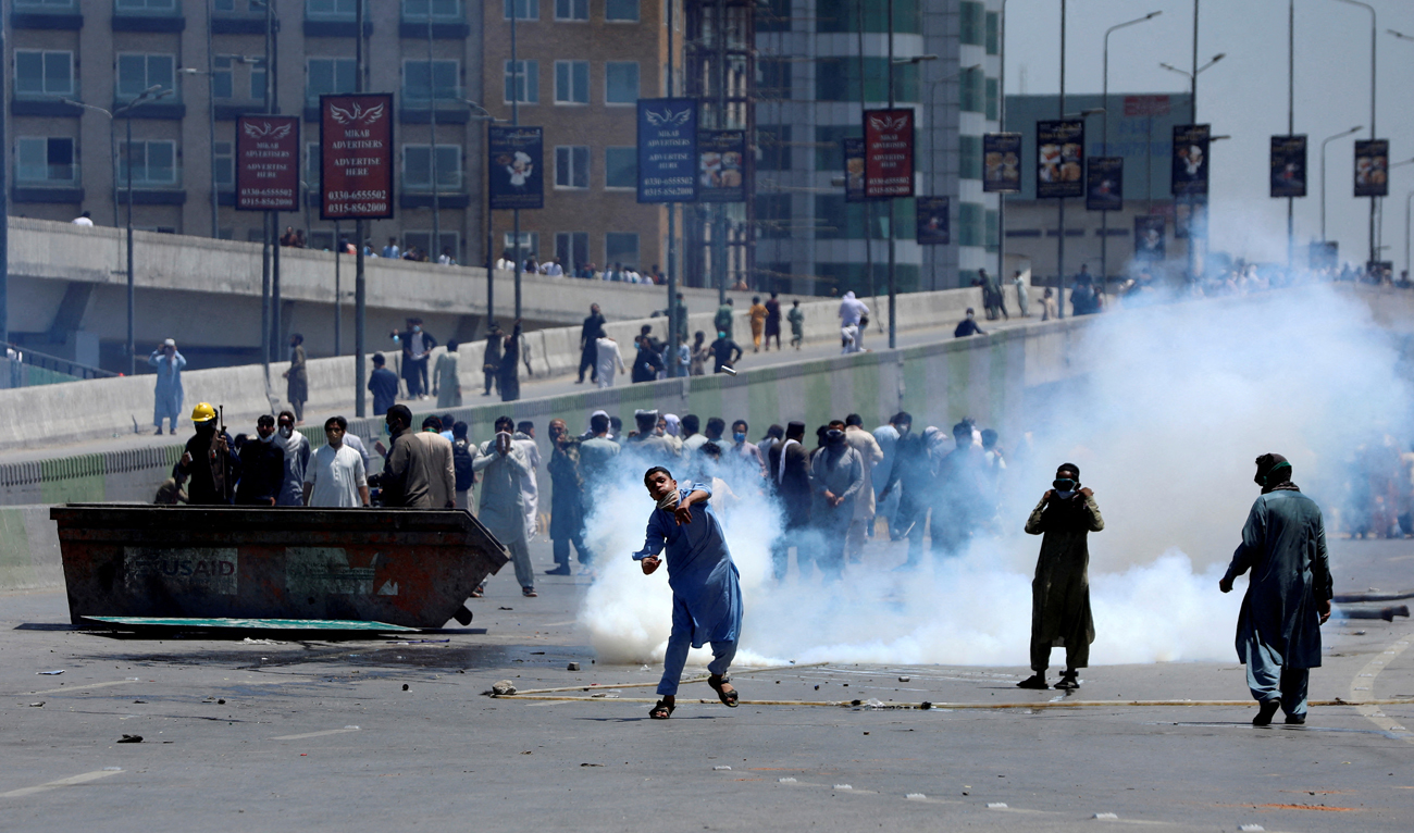 Supporters of Pakistan's former Prime Minister Imran Khan throw stones at police during a protest against Khan's arrest, in Peshawar, Pakistan, May 10, 2023. (Photo courtesy: REUTERS/File)