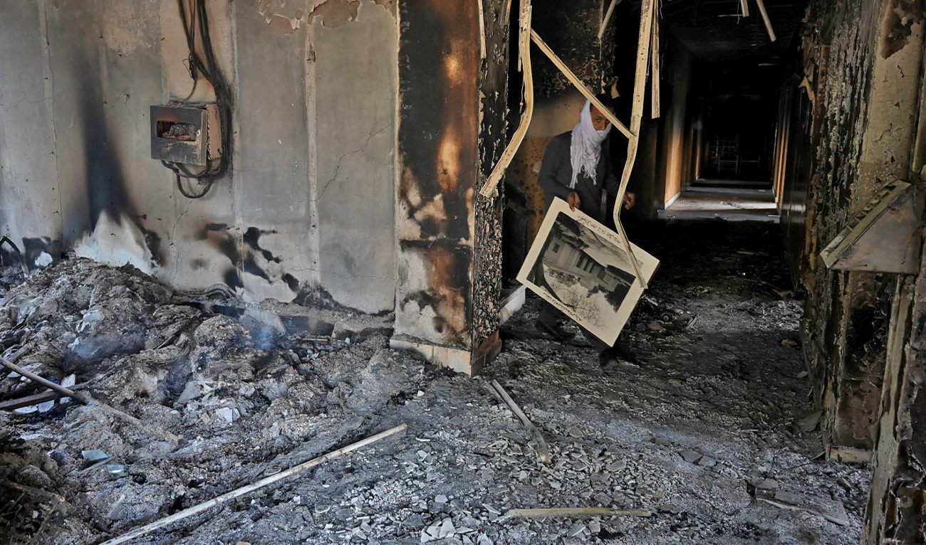 A man walks inside the burnt Radio Pakistan building a day after protests by Pakistan Tehreek-e-Insaf (PTI) party activists and supporters of former Pakistan's Prime Minister Imran Khan, in Peshawar on May 11, 2023. (AFP/File)