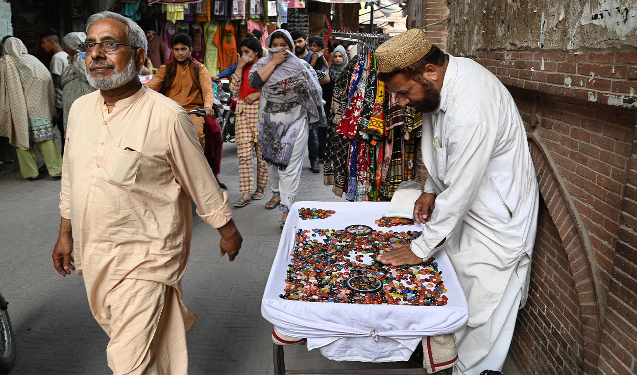 A vendor selling stones waits for customers at a market in Lahore, Pakistan, on May 29, 2023. (AFP)