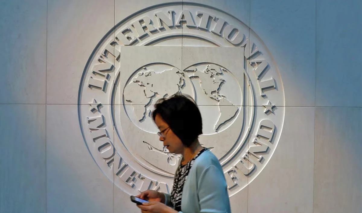 A woman walks past the International Monetary Fund (IMF) logo at its headquarters in Washington, US, on May 10, 2018. (REUTERS/File)