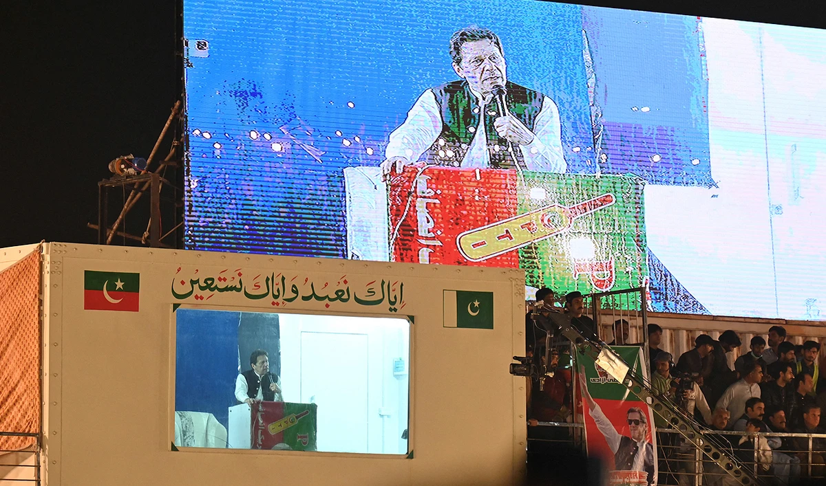 In this file picture, taken on March 26, 2023, Pakistan's former prime minister Imran Khan (bottom L) speaks to his supporters from behind a bulletproof shield at a rally in Lahore. (Photo courtesy: AFP/File)