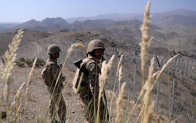 In this photo taken on October 18, 2017, Pakistani soldiers keep vigil next to fencing along the Afghan border at Kitton Orchard Post in Pakistan's North Waziristan tribal agency. (Photo courtesy: AFP/ File)