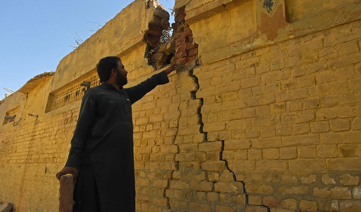 A resident checks a damaged wall of his house following an earthquake in the remote mountainous district of Harnai on October 7, 2021. (AFP/File)