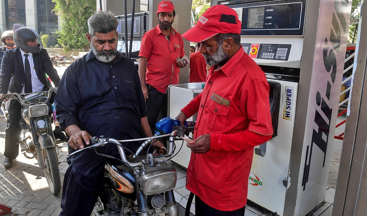 This picture taken on January 30, 2023 shows resident Saleem Qureshi (C) filling petrol in his motorcycle at a gasoline station in Pakistan's port city of Karachi. (AFP/File)