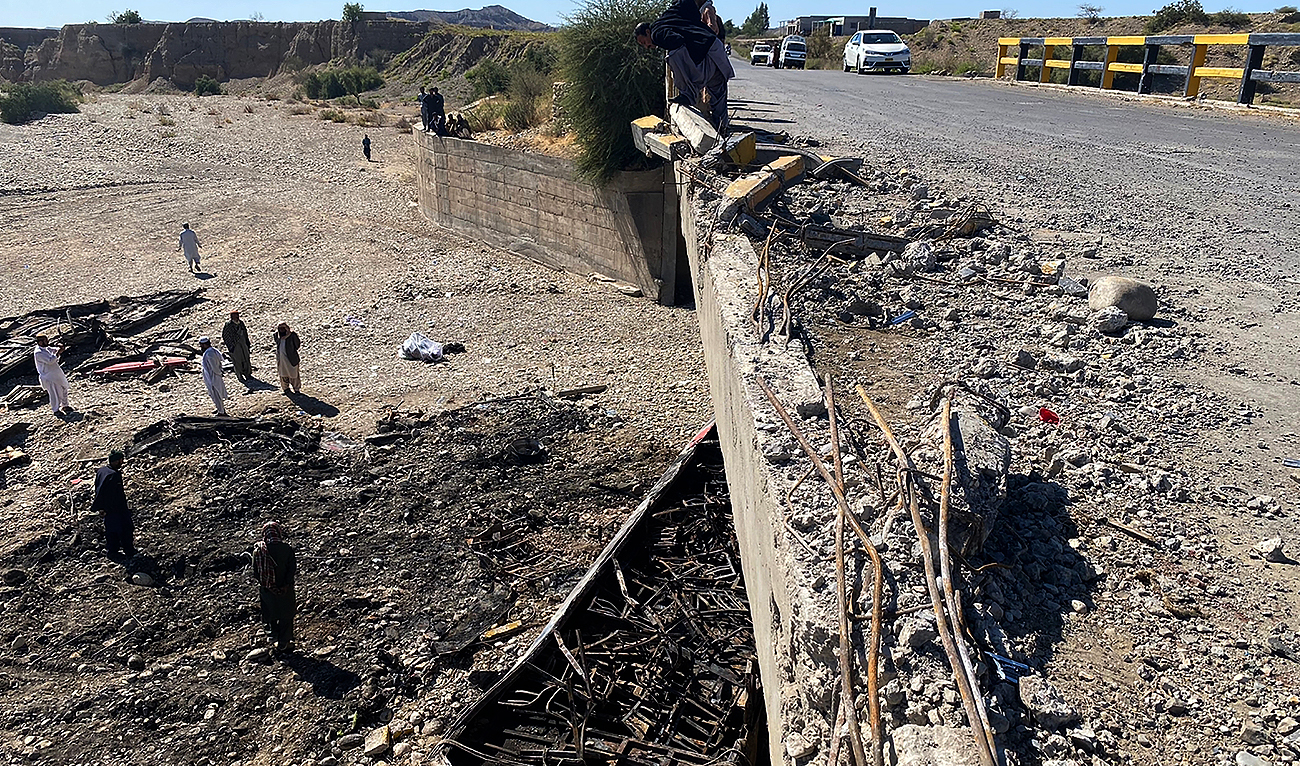 Residents look at the wreckage of a burnt passenger bus at Bela in Lasbela district of Pakistan's Balochistan province on January 29, 2023. (Photo courtesy: AFP/File)