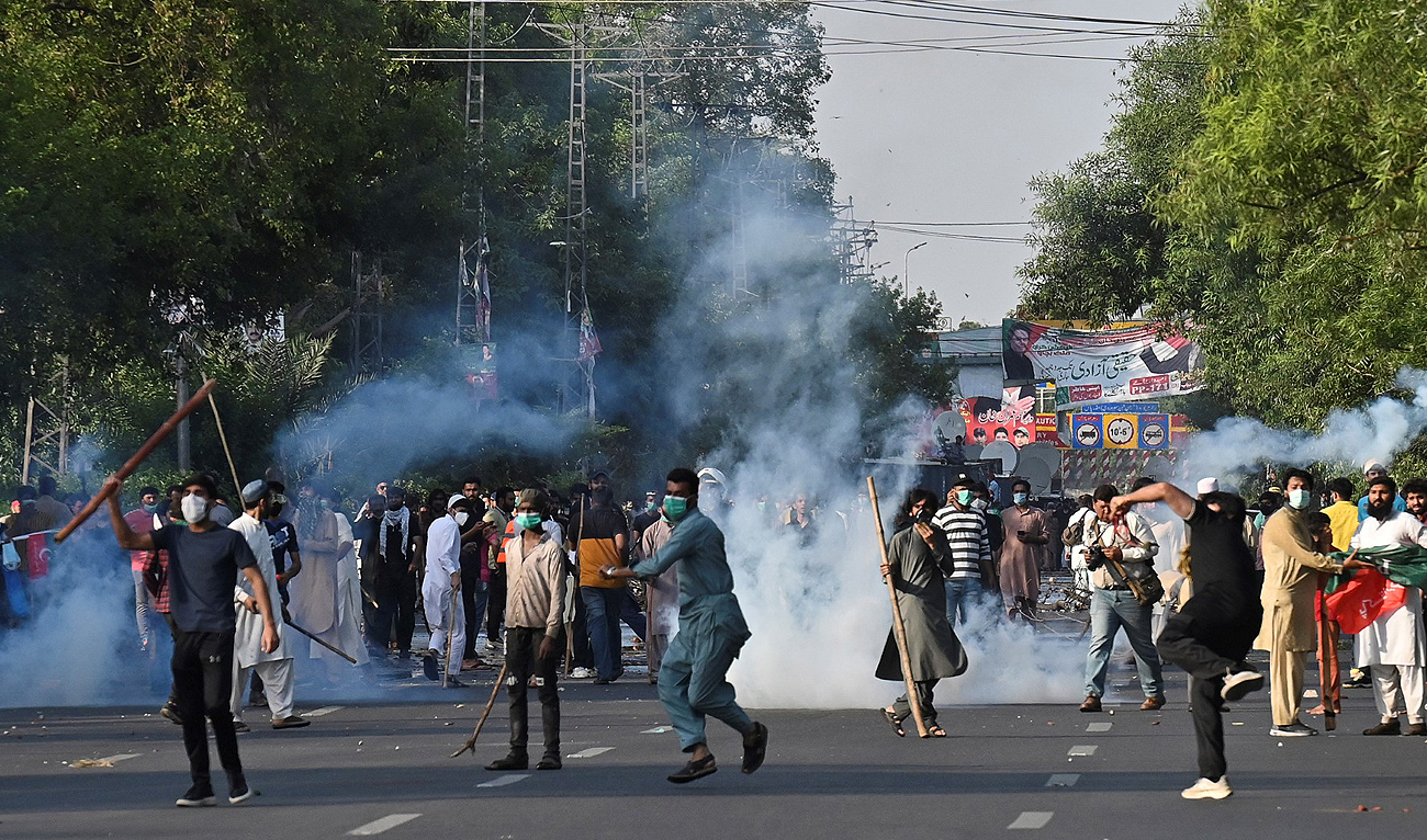 In this picture, taken on May 9, 2023, supporters of former Pakistan's Prime Minister Imran Khan clash with police during a protest against the arrest of their leader in Lahore. (Photo courtesy: AFP/File)