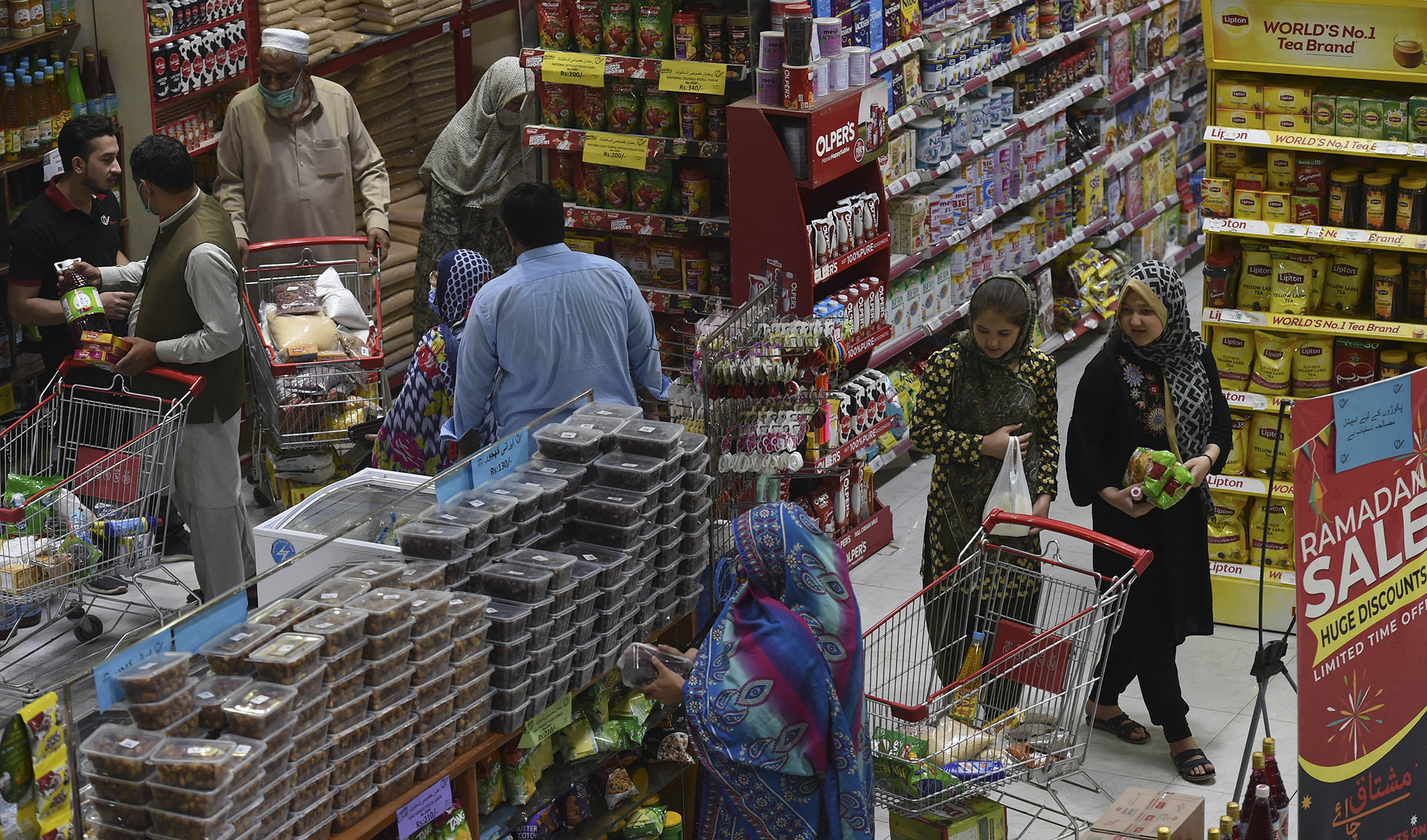 People buy grocery items at a store in Peshawar, Pakistan, on April 5, 2021. (AFP/File)