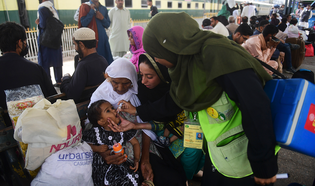 A health worker administers polio vaccine drops to a child at a railway station during a vaccination campaign in Karachi on March 14, 2023. (Photo courtesy: AFP)