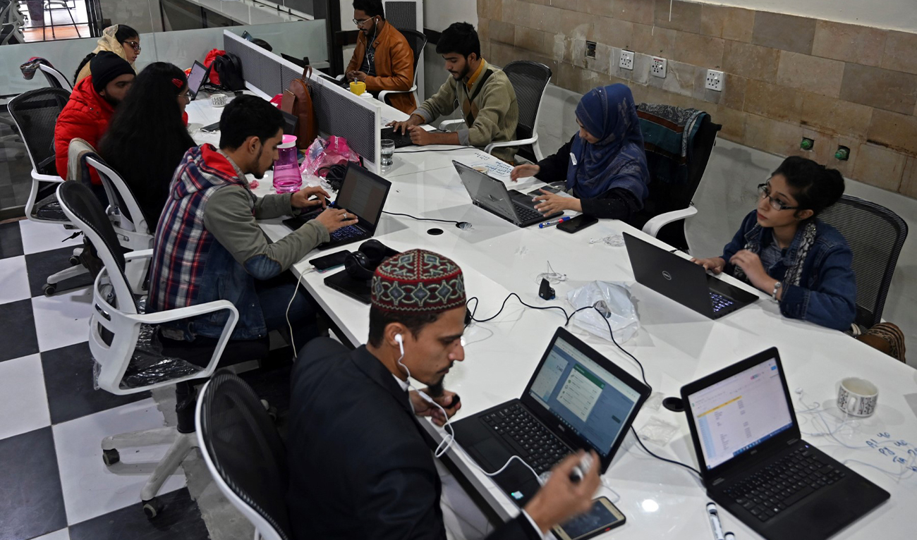 In this picture taken on January 8, 2022, employees of Taza Transforming Agriculture talk with customers at a call centre in Lahore, Pakistan. (AFP/File)