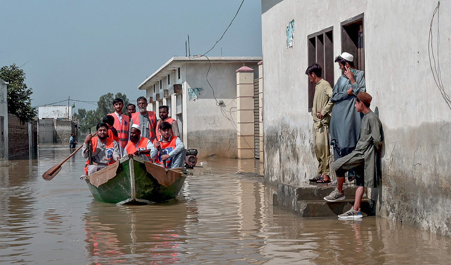 Armed members of Alkhidmat Foundation patrol on a boat at a residential area submerged in floodwater in Nowshera of Pakistan's Khyber Pakhtunkhwa province on August 29, 2022. (AFP/File)