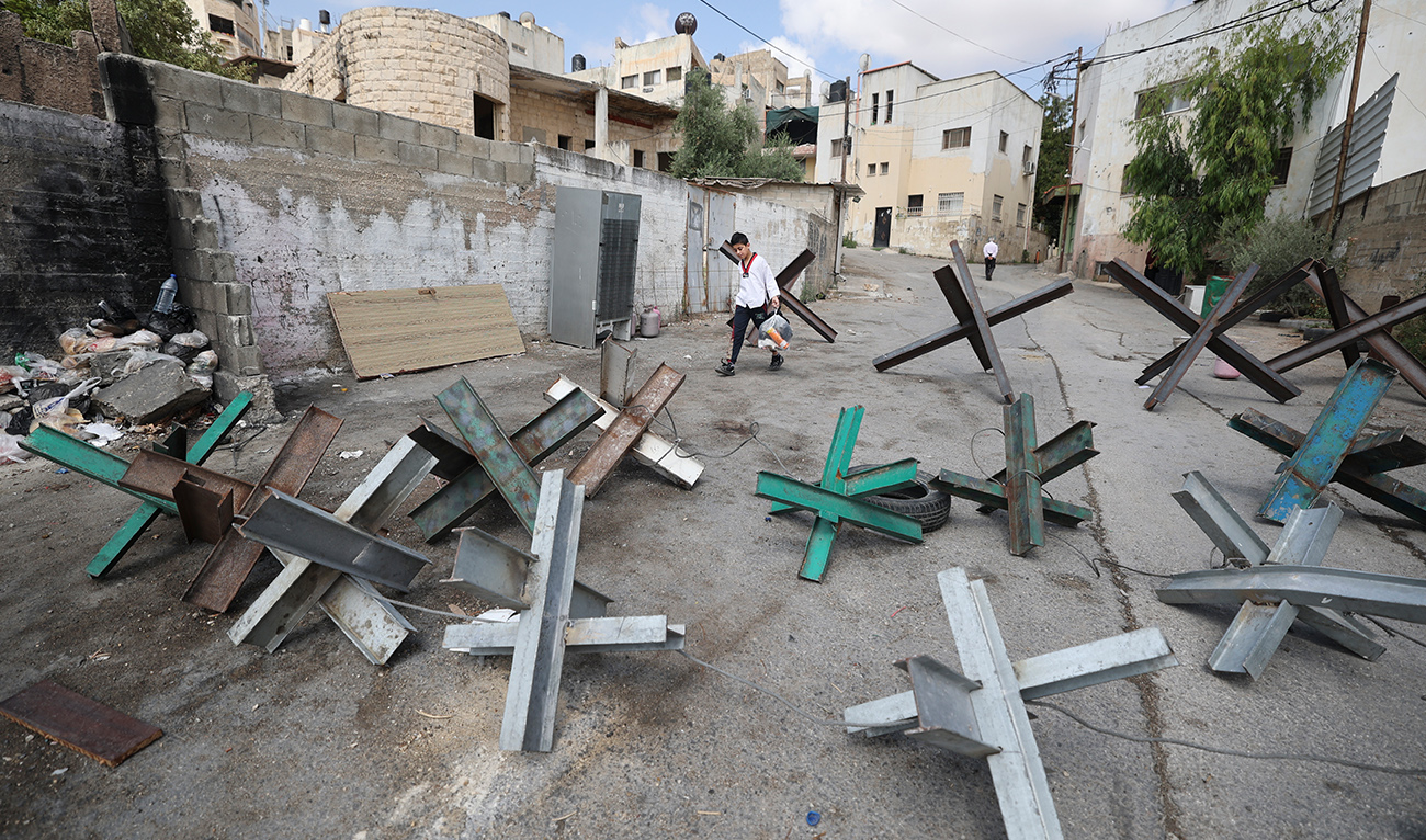 A boy navigates through barricades set up by Palestinians in an effort to prevent Israeli security forces from entering Jenin, in the occupied West Bank on June 20, 2023. (AFP)
