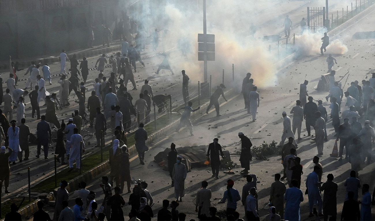 Pakistan Tehreek-e-Insaf (PTI) party supporters of former Pakistan's Prime Minister Imran gather amid teargas fired by police during a protest against the arrest of their leader, in Peshawar, Pakistan, on May 9, 2023. (AFP/File)