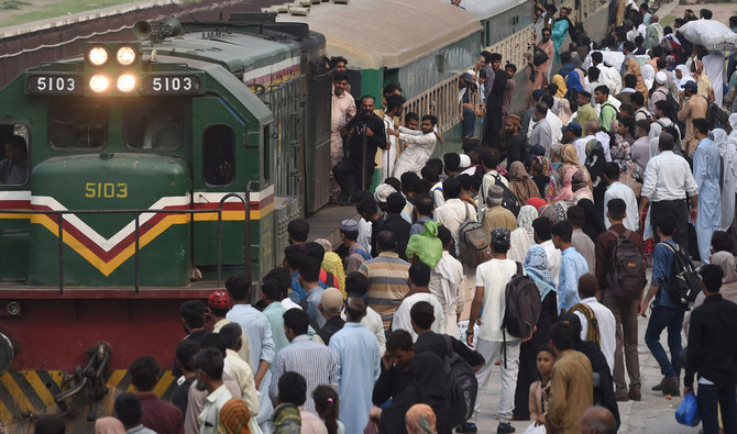 People board a train at a railway station as they return home ahead of Eid al-Adha in Lahore on July 7, 2022. (AFP/File)
