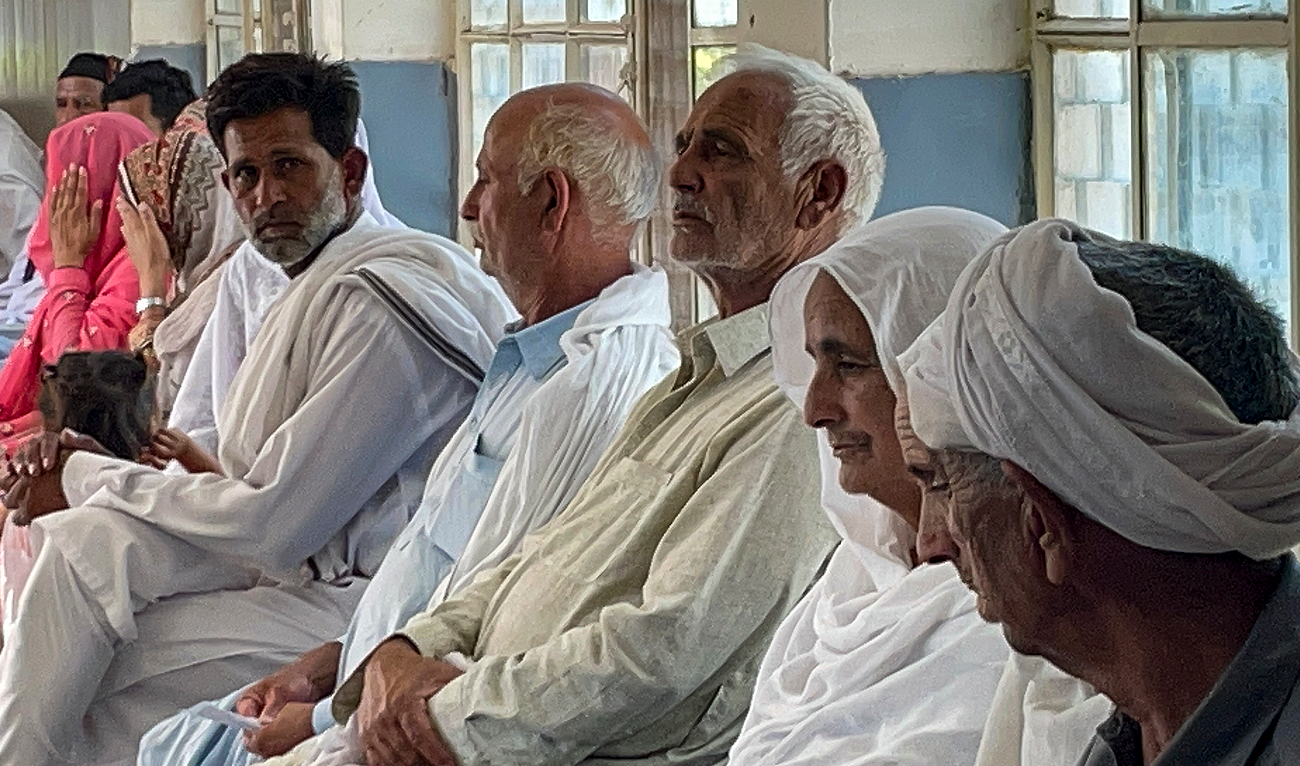 In this picture taken on June 20, 2023, relatives of migrants, who went missing after an overloaded trawler capsized and sank in the Ionian Sea, wait to provide DNA samples at a hospital in Bandli village, in Pakistan-administered Kashmir. (AFP/File)