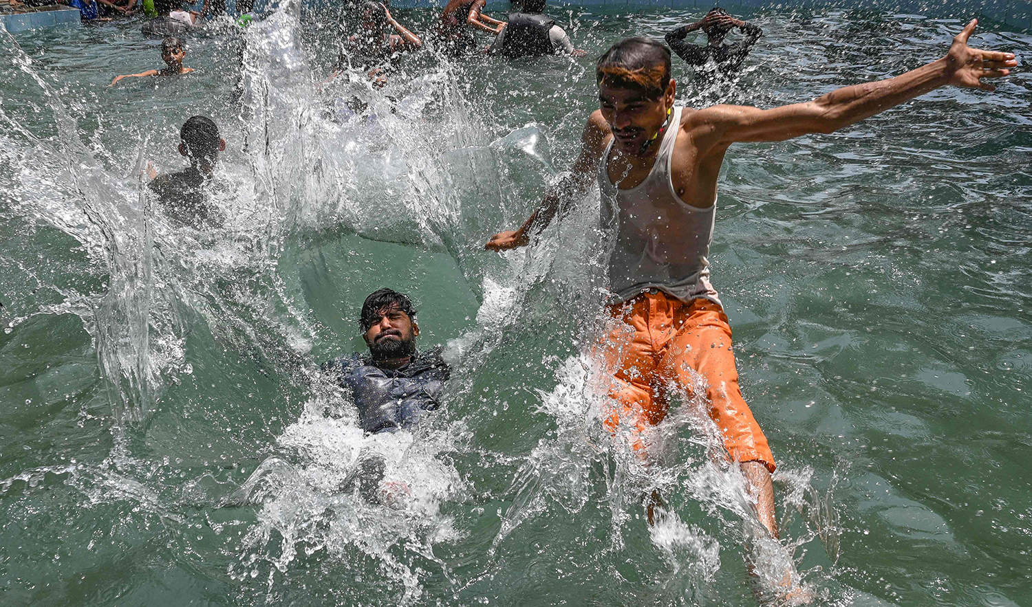 Youths cool themselves in a swimming pool on a hot summer day in Lahore, Pakistan on June 22, 2023. (AFP)
