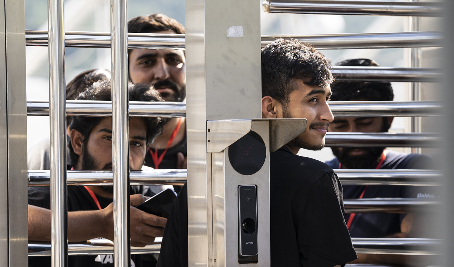 A man waits at the turnstiles and speaks with survivors of a deadly migrant boat sinking at a migrant camp in Malakasa north of Athens, on June 19, 2023. (AP)